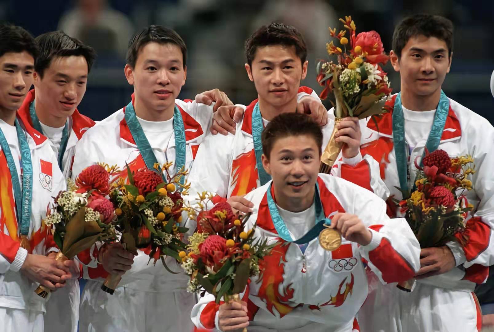 2000年，在悉尼奥运会上，中国男子体操队获得团体冠军。图为冠军成员合影，左三为黄旭。.jpg