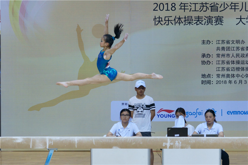 形影齐飞（2018.6.6摄自在常州举办的江苏省第四届青少年体操节。平衡木比赛中，运动员跨跳瞬间恰好与宣传海报上的影子“形影齐飞”)+王汇廉+13961111473.jpg